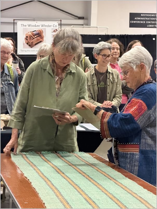 Rolly Thompson, right, review scores for the Aurora Colony Guild�s Team Fascinator place shawl with Sheep-to-Shawl Judge Kathy Nelson. Photo: Liz Hubbard.